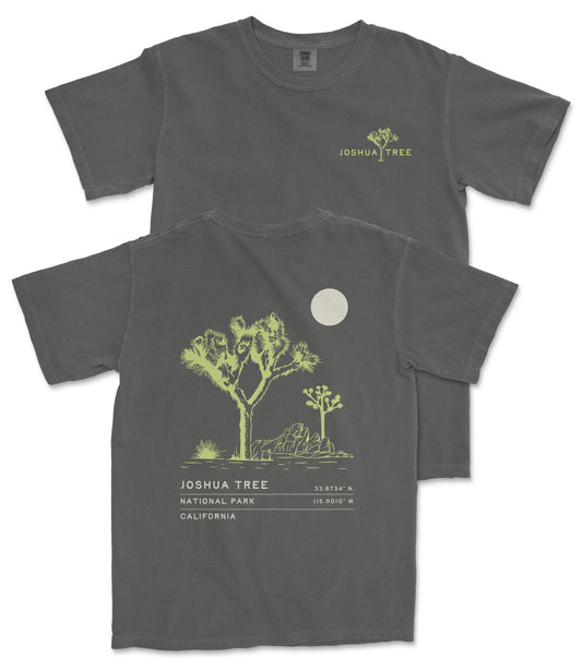 a gray t-shirt with a graphic design depicting a tree and a moon. The t-shirt has text on the back that reads "JOSUA TREE 33.734 N. CA. 1019 W."