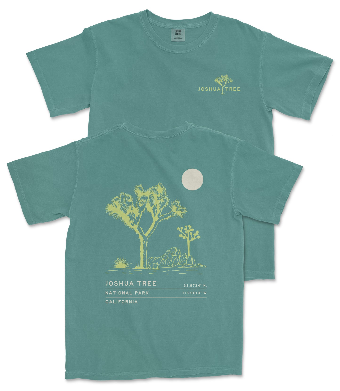 a green t-shirt with a graphic design depicting a desert landscape with a tree and a moon. The t-shirt has text printed on it that reads "JOSUA TREE" and "33.74° N. 115.907 W. CA. N.C. U.S.A."