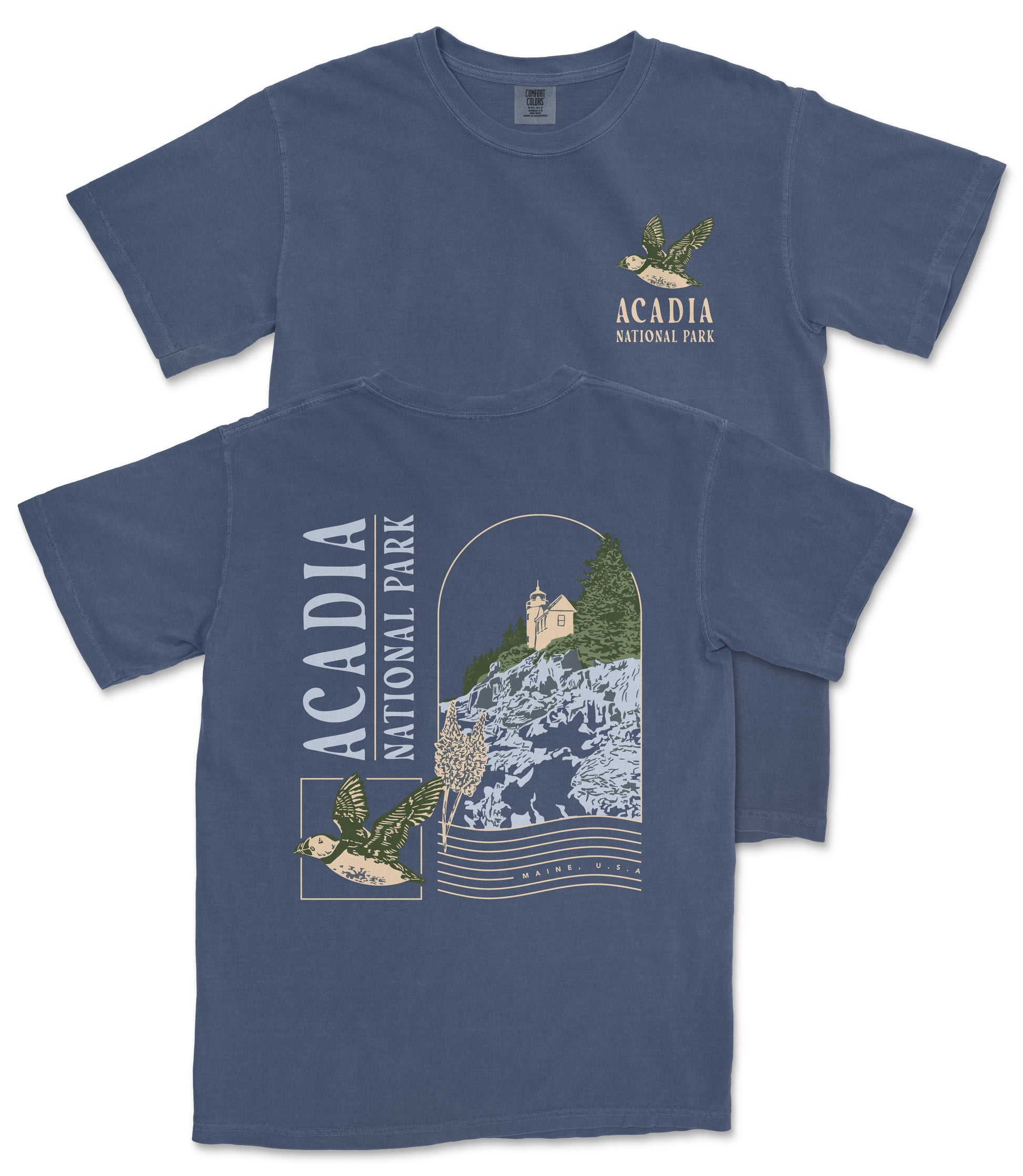A blue t-shirt with a graphic design depicting a bird flying over a mountainous landscape, along with text that reads "ACADIA NATIONAL PARK".