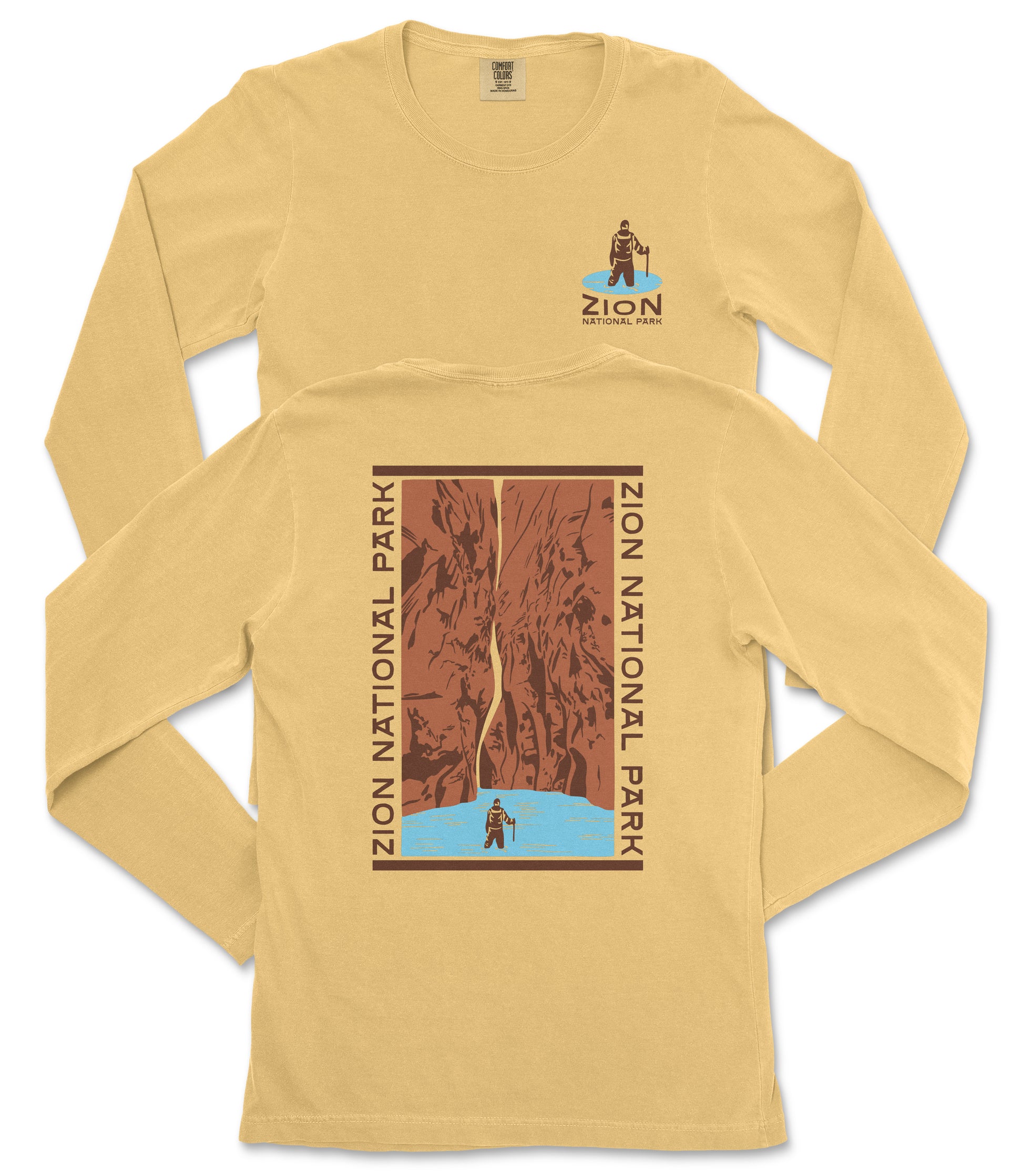 A yellow long-sleeved t-shirt with a graphic design depicting a person standing on a cliff overlooking a body of water, surrounded by mountains.
