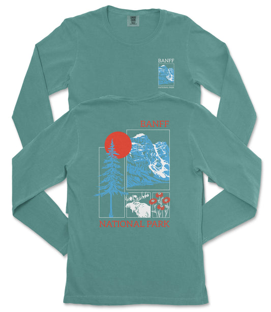 A long-sleeved teal green t-shirt with a graphic design featuring a mountain range, a red sun, and various flora and fauna elements.