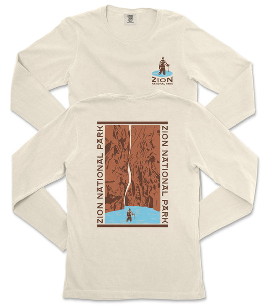 a white long-sleeved t-shirt with a graphic design depicting a person standing on a cliff overlooking a body of water.