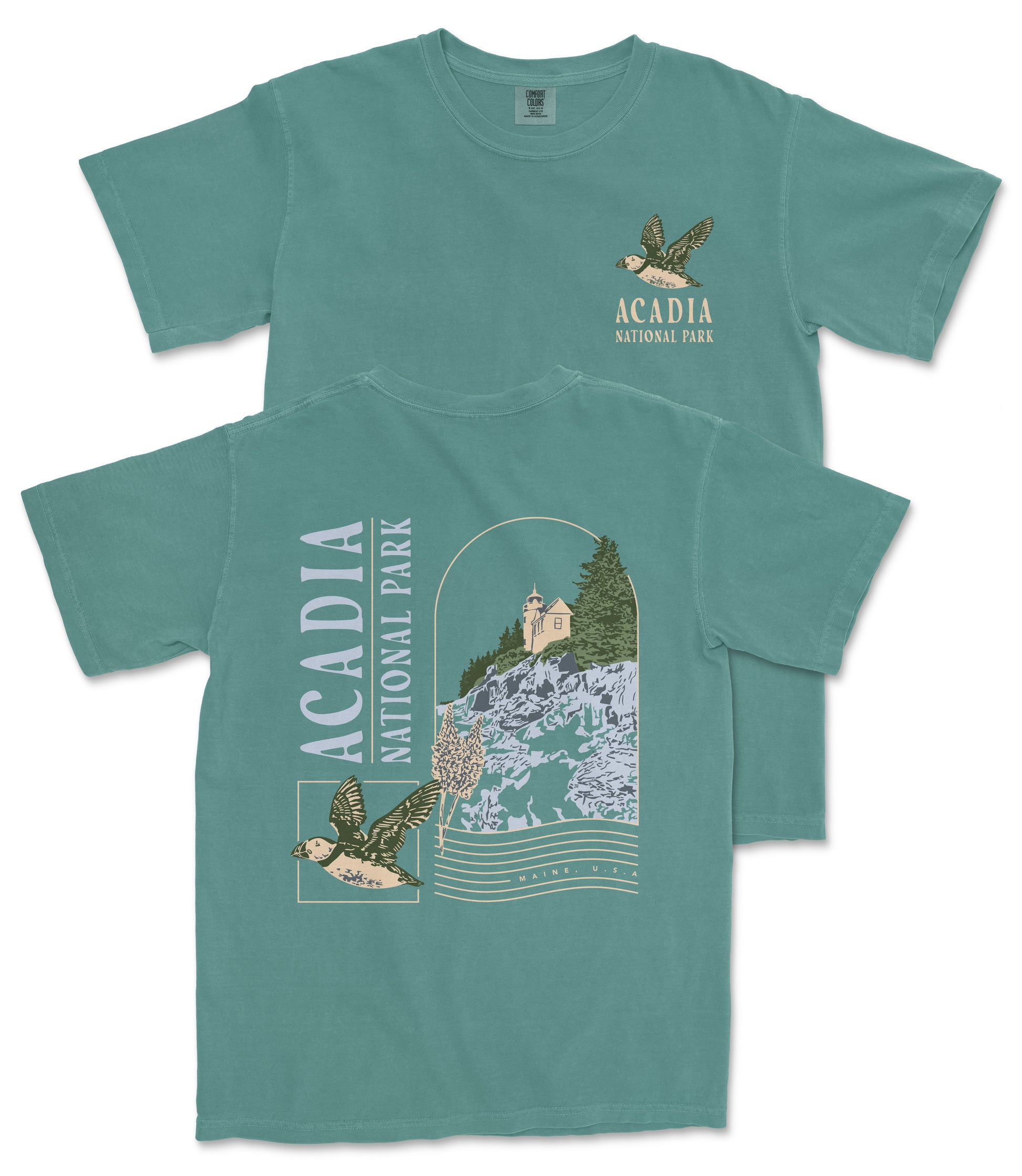 A green t-shirt with a graphic design depicting a bird and a landscape with a building, along with text that says "ACADIA NATIONAL PARK".