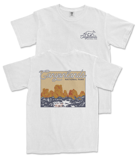 A white t-shirt with a graphic design depicting a scenic landscape with mountains and a river.
