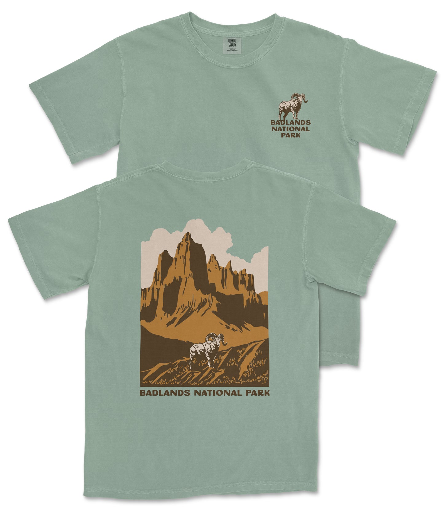 A green t-shirt with a graphic design depicting a mountain landscape and a bighorn sheep, along with the text "Badlands National Park".