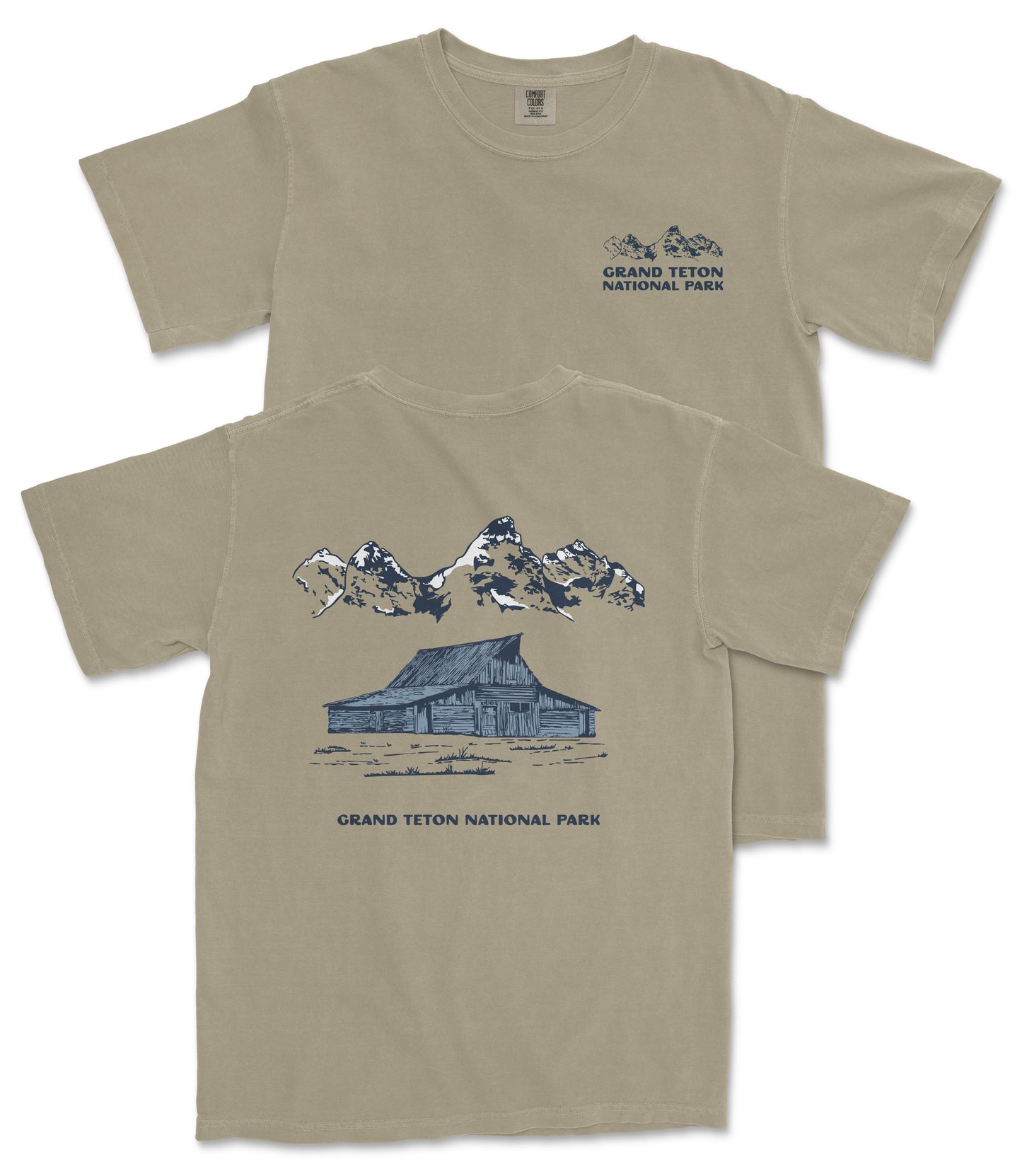 A beige t-shirt with a graphic design depicting a cabin and mountains, along with the text "Grand Teton National Park" printed on the back.
