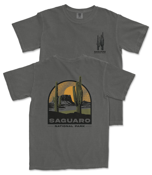 a gray t-shirt with a graphic design depicting a desert landscape with cacti and mountains, along with the text "Saguaro National Park".