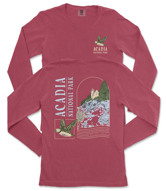 A red long-sleeved t-shirt with the text "ACADIA NATIONAL PARK" printed on it, along with an illustration of a bird and a landscape scene.