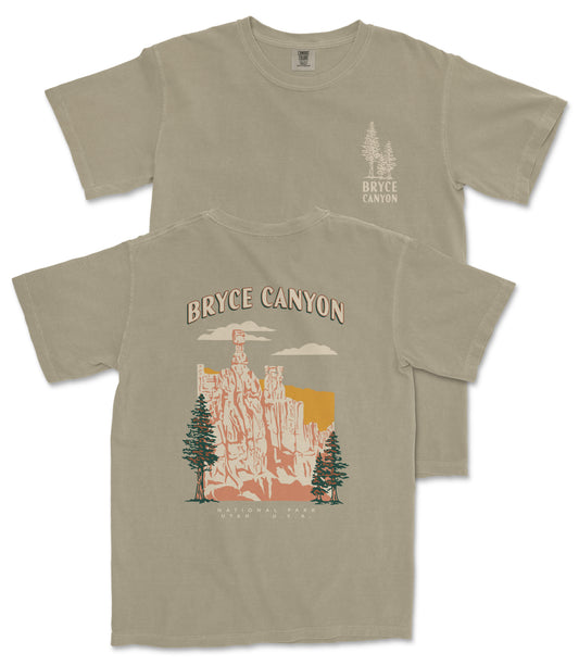 a t-shirt with a graphic design depicting a scenic landscape with a mountain range and trees.