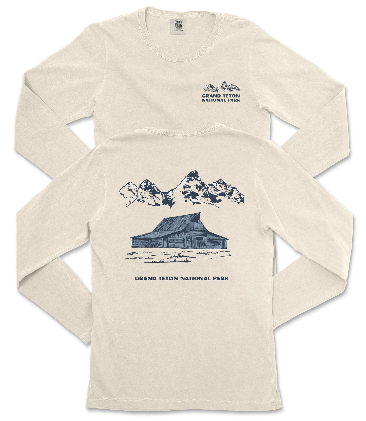a cream-colored long-sleeved t-shirt with a graphic design depicting a cabin and mountains, along with the text "Grand Teton National Park" printed on the back.