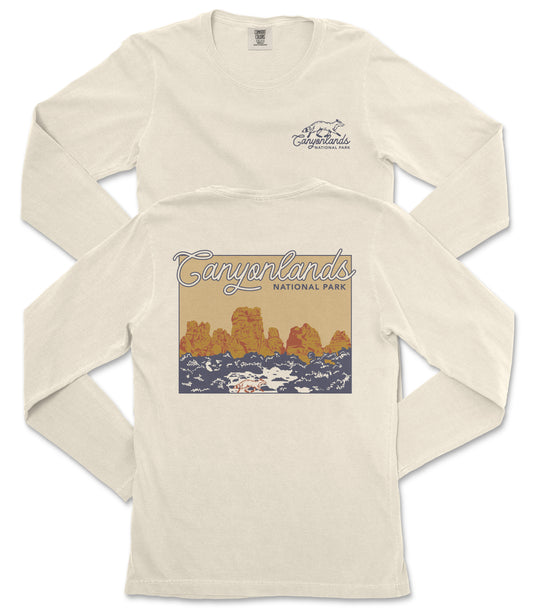A white long-sleeved t-shirt with a graphic design depicting a scenic landscape, including mountains and a body of water.