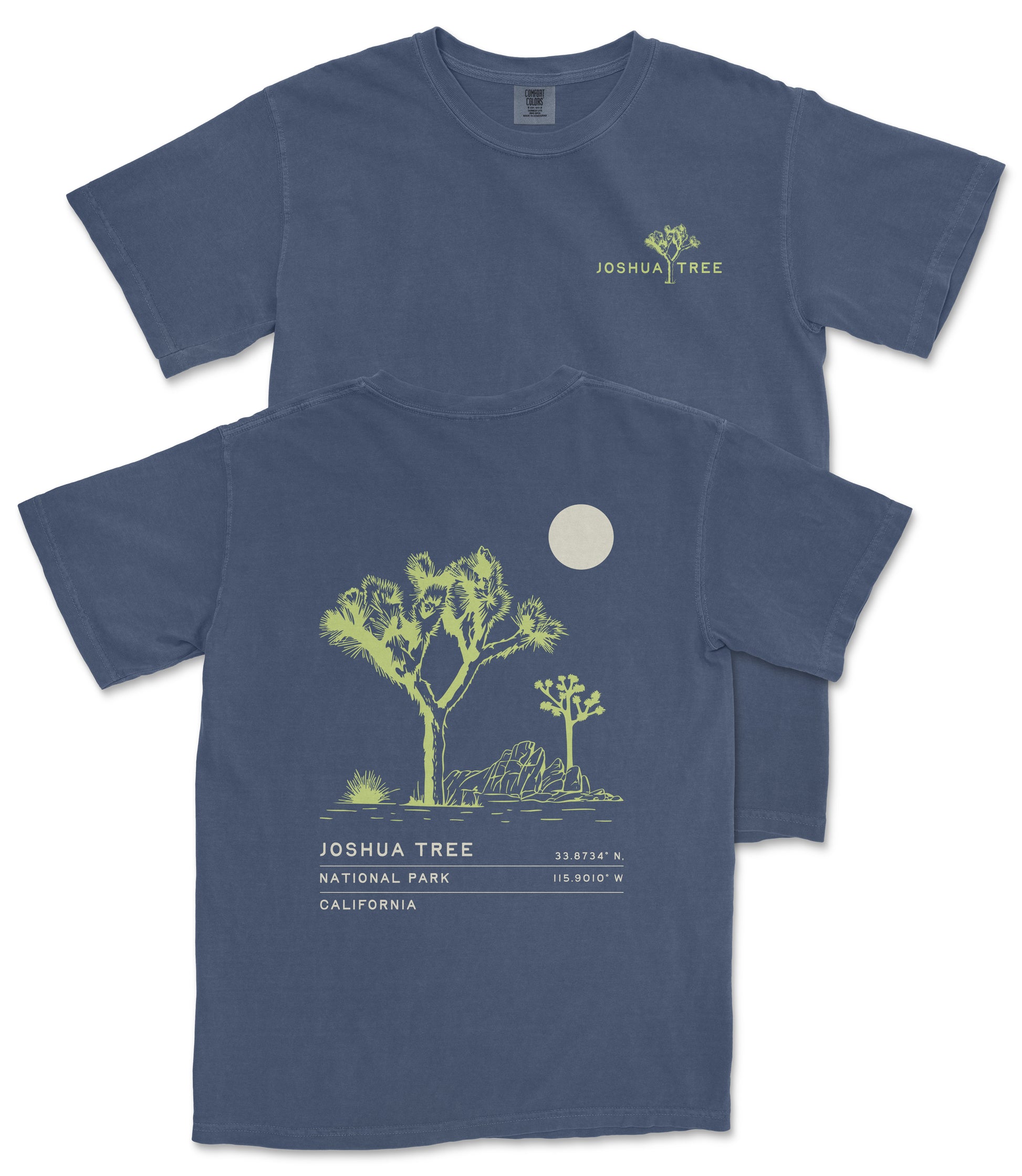 a blue t-shirt with a graphic design depicting a desert landscape with a tree and a moon. The design includes text that reads "JOSUA TREE" and "33.734 N. 115.918 W", indicating the location of Joshua Tree National Park in California.