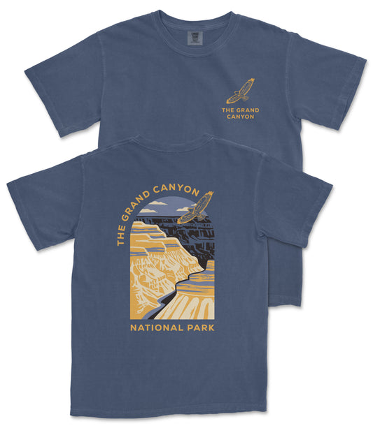 A blue t-shirt with a graphic design depicting the Grand Canyon, featuring a yellow and black color scheme.