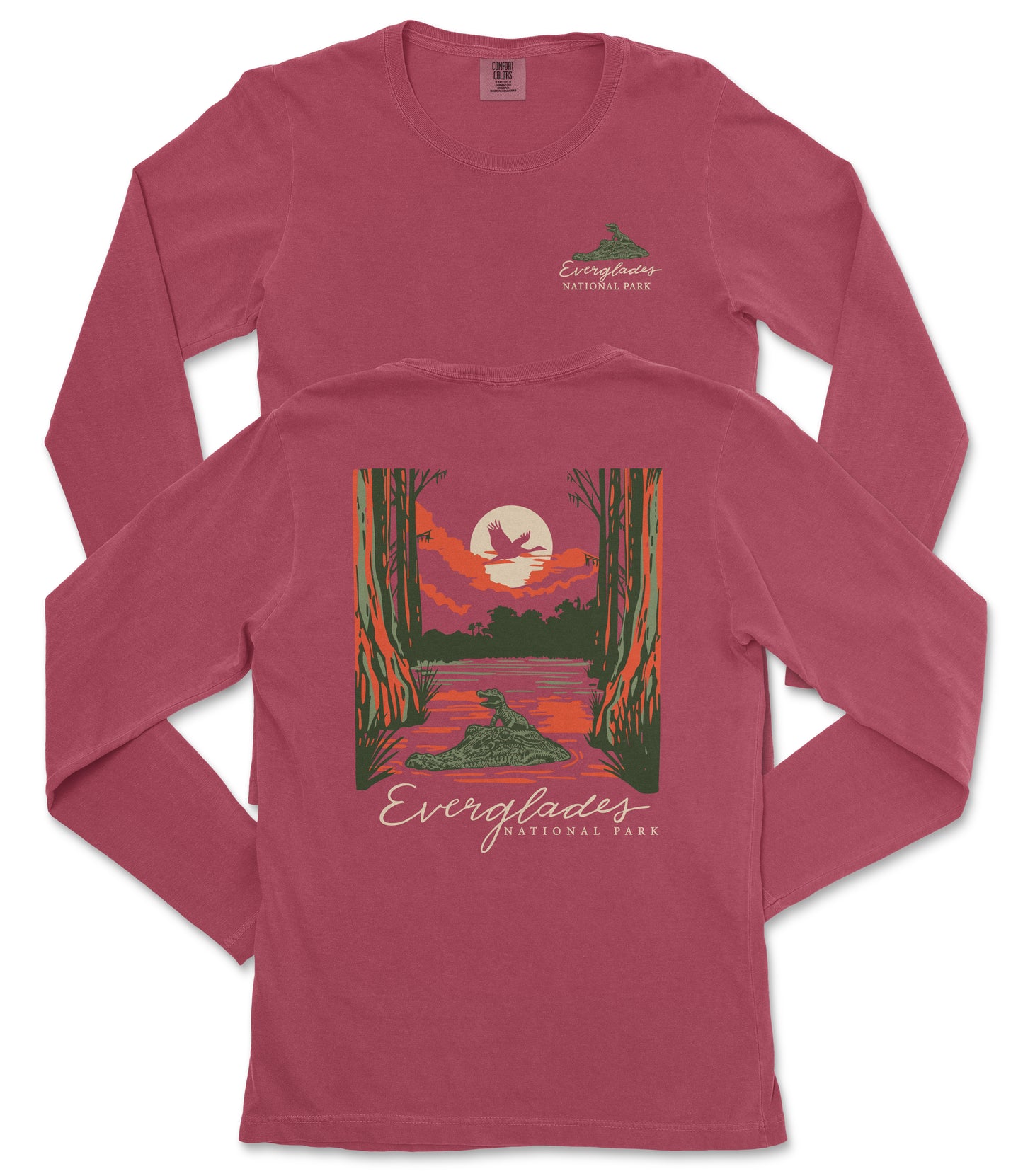 A red long-sleeved t-shirt with a graphic design depicting a sunset over a lake, surrounded by trees and wildlife.