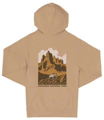a beige hoodie with a graphic design depicting a mountain landscape and a person riding a horse. The text "Badlands National Park" is printed below the graphic.