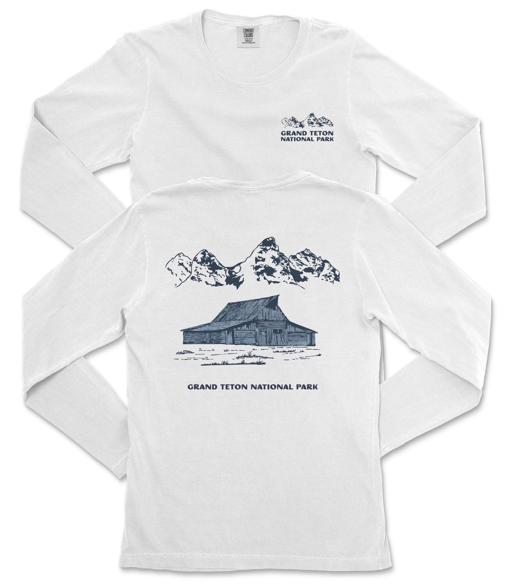 A white long-sleeved t-shirt with a graphic design depicting a cabin and mountains, along with text that reads "Grand Teton National Park".