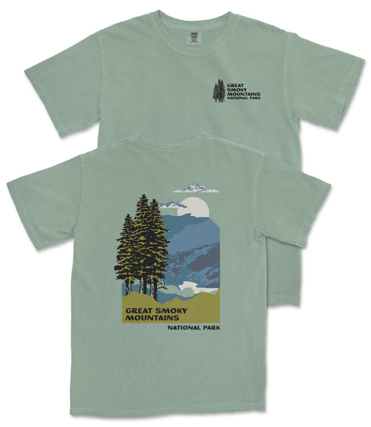 A green t-shirt with a graphic design depicting a mountain landscape with pine trees, a full moon, and clouds. The text on the t-shirt reads "GREAT SMOKY MOUNTAINS NATIONAL PARK".
