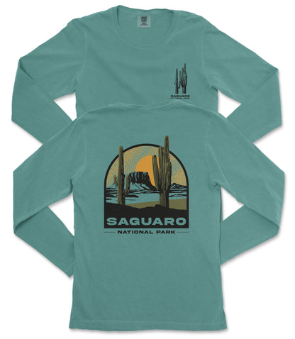 A turquoise long-sleeve t-shirt with a graphic design depicting a desert landscape with a cactus and mountains, along with the text "Saguaro National Park".