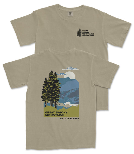 a t-shirt with a graphic design depicting a scenic mountain landscape with pine trees, mountains, and a full moon.