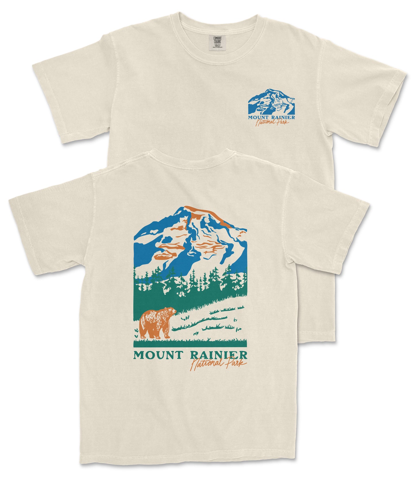 a beige t-shirt with a graphic design depicting a mountain landscape, including a bear and trees. The text on the t-shirt reads "Mount Rainier National Forest" and "National Forest".