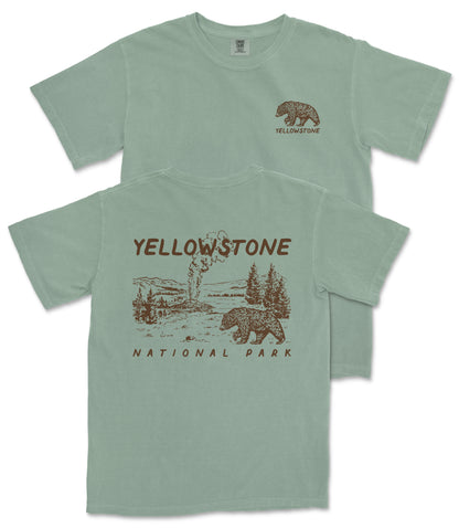 A green t-shirt with a graphic design depicting a bear and a landscape, along with the text "Yellowstone National Park" printed on it.