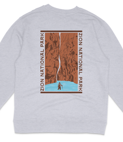 A gray sweatshirt with a graphic design depicting a person standing in front of a canyon with a waterfall.