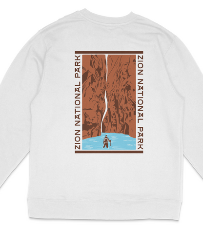 A white long-sleeved shirt with a graphic design depicting a person standing in a river, surrounded by a rocky cliff face.