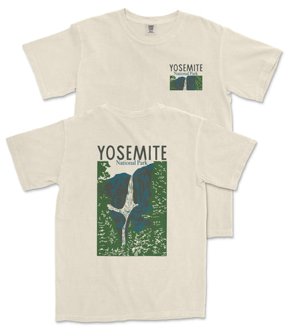A beige t-shirt with a graphic design depicting a waterfall and mountains, along with the text "Yosemite National Park" printed on it.
