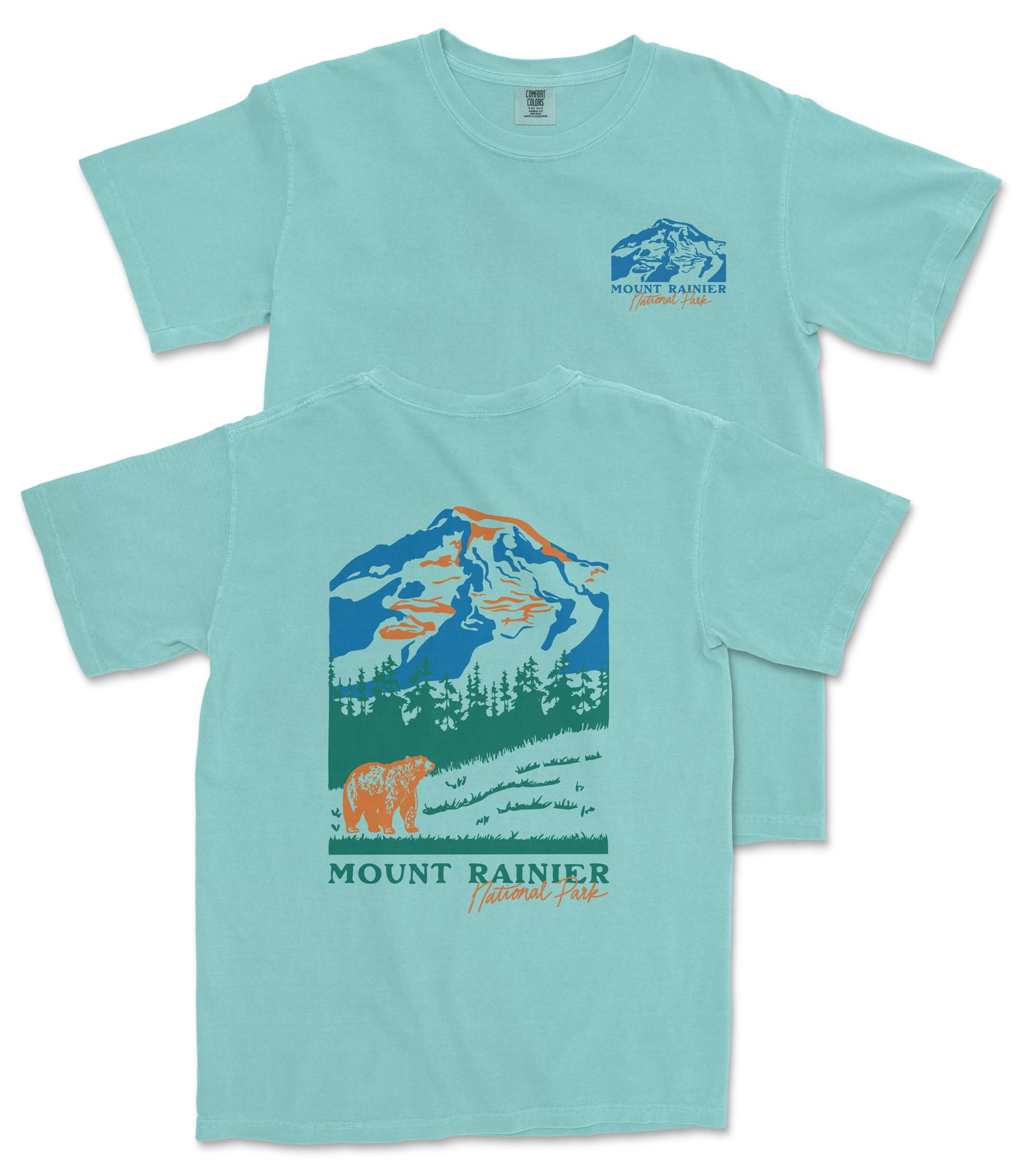 A light blue t-shirt with a graphic design depicting a mountain landscape, including a mountain peak, trees, and a bear. The text "MOUNT RAINER" and "National Forest" is printed on the t-shirt.