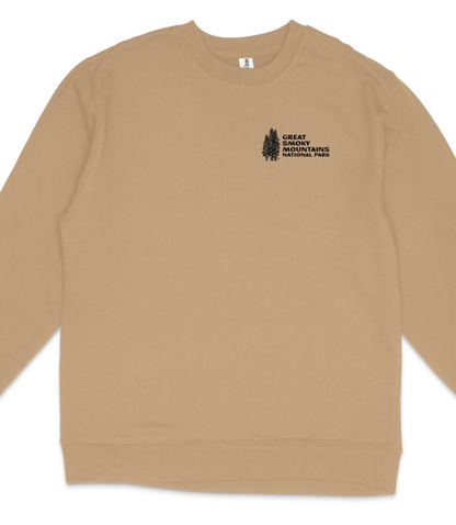 A tan long-sleeved shirt with a black graphic design on the left side, which appears to be a logo or emblem.