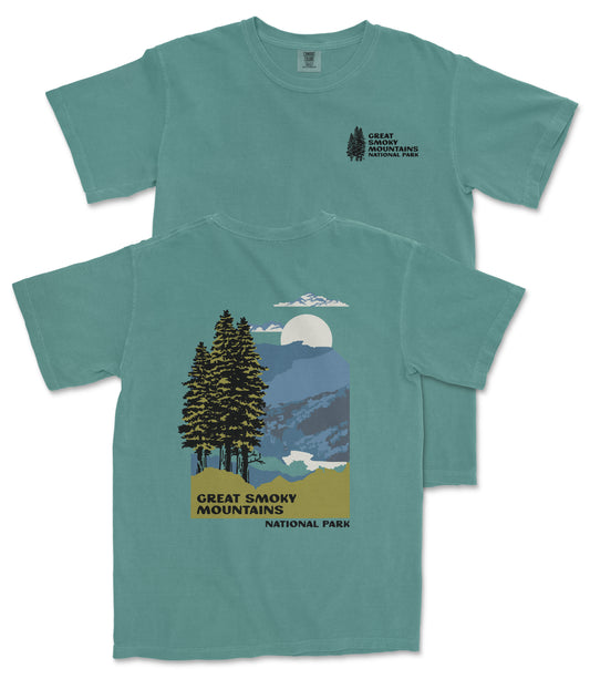 A green t-shirt with a graphic design depicting a mountain landscape with pine trees, a full moon, and clouds. The text on the t-shirt reads "GREAT SMOKY MOUNTAINS NATIONAL PARK".