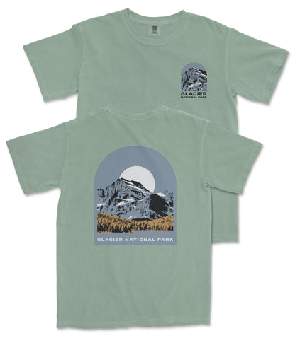 A green t-shirt with a graphic design depicting a mountain landscape and the text "Glacier National Park" printed on it.