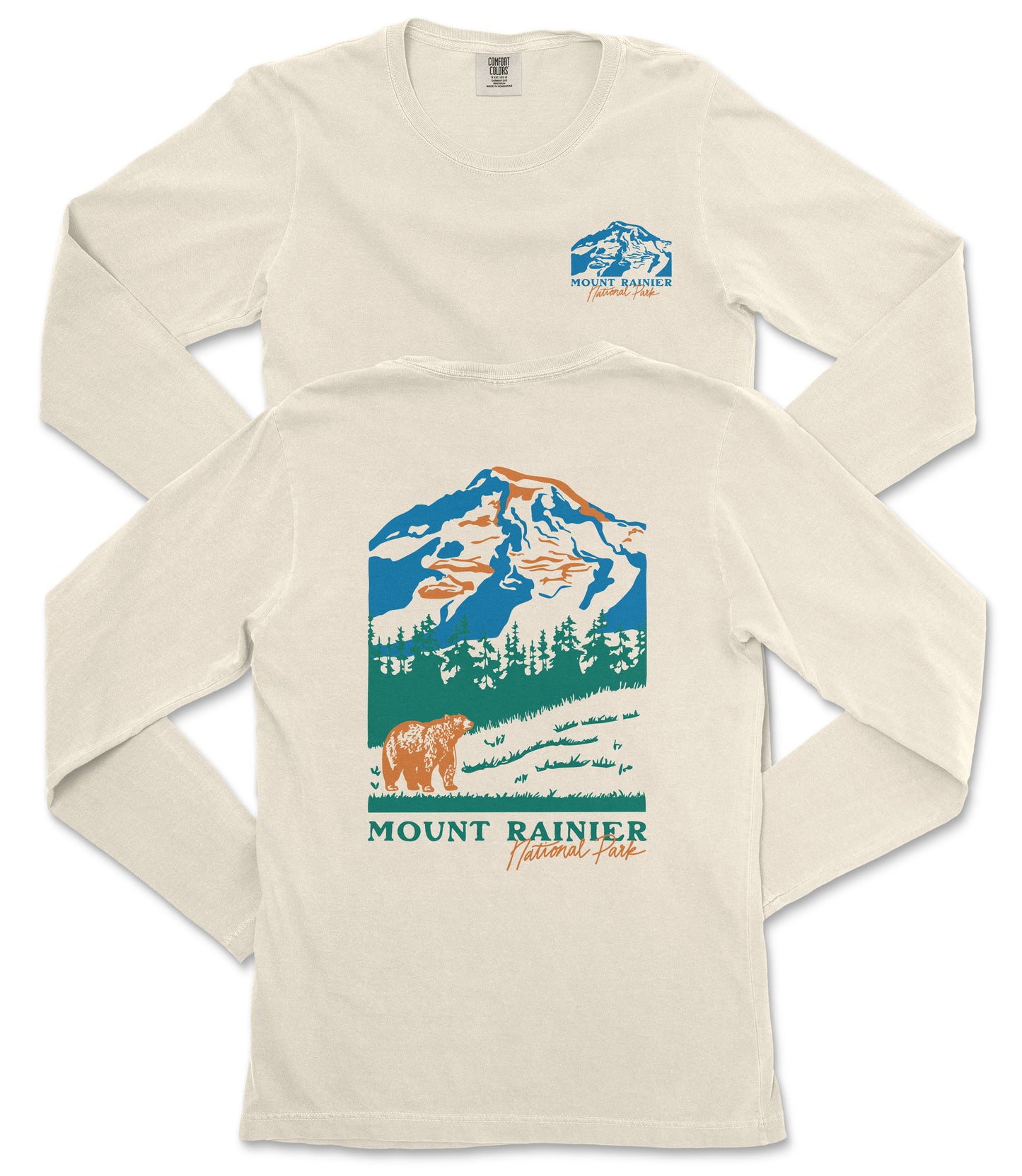 a cream-colored long-sleeved t-shirt with a graphic design depicting a mountain landscape, including a bear and trees. The text "MOUNT RAINIER" is prominently displayed, indicating the location or theme of the design.