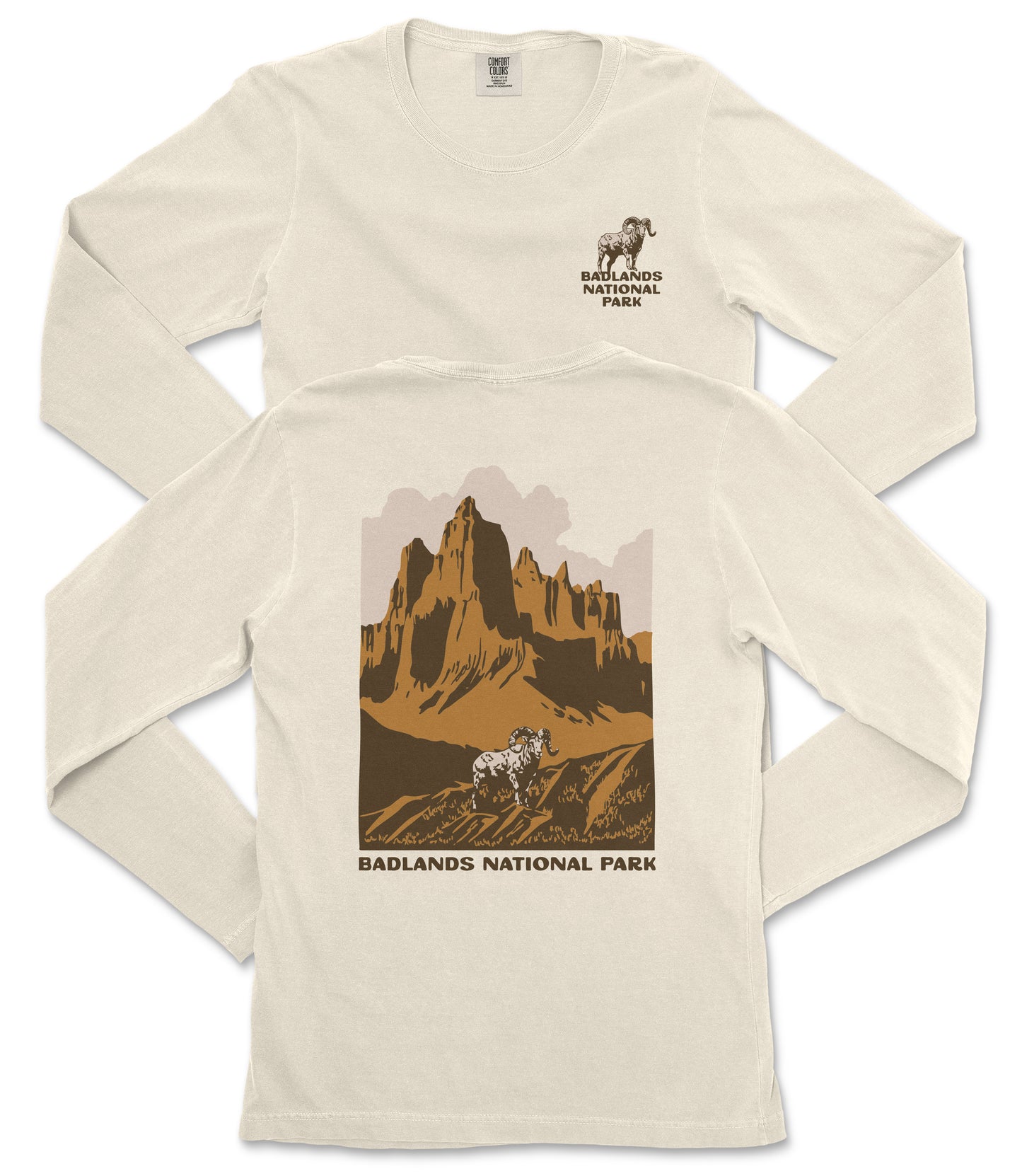 a white long-sleeved t-shirt with a graphic design depicting a mountain landscape and a goat. The text "BADLANDS NATIONAL PARK" is printed below the mountain and goat illustration.