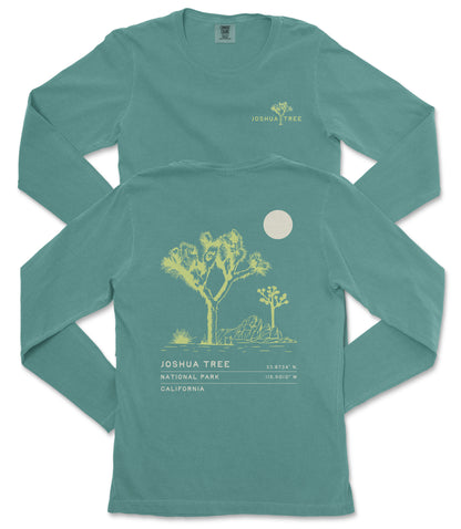 a teal long-sleeve t-shirt with a graphic design depicting a tree and a moon on the back.