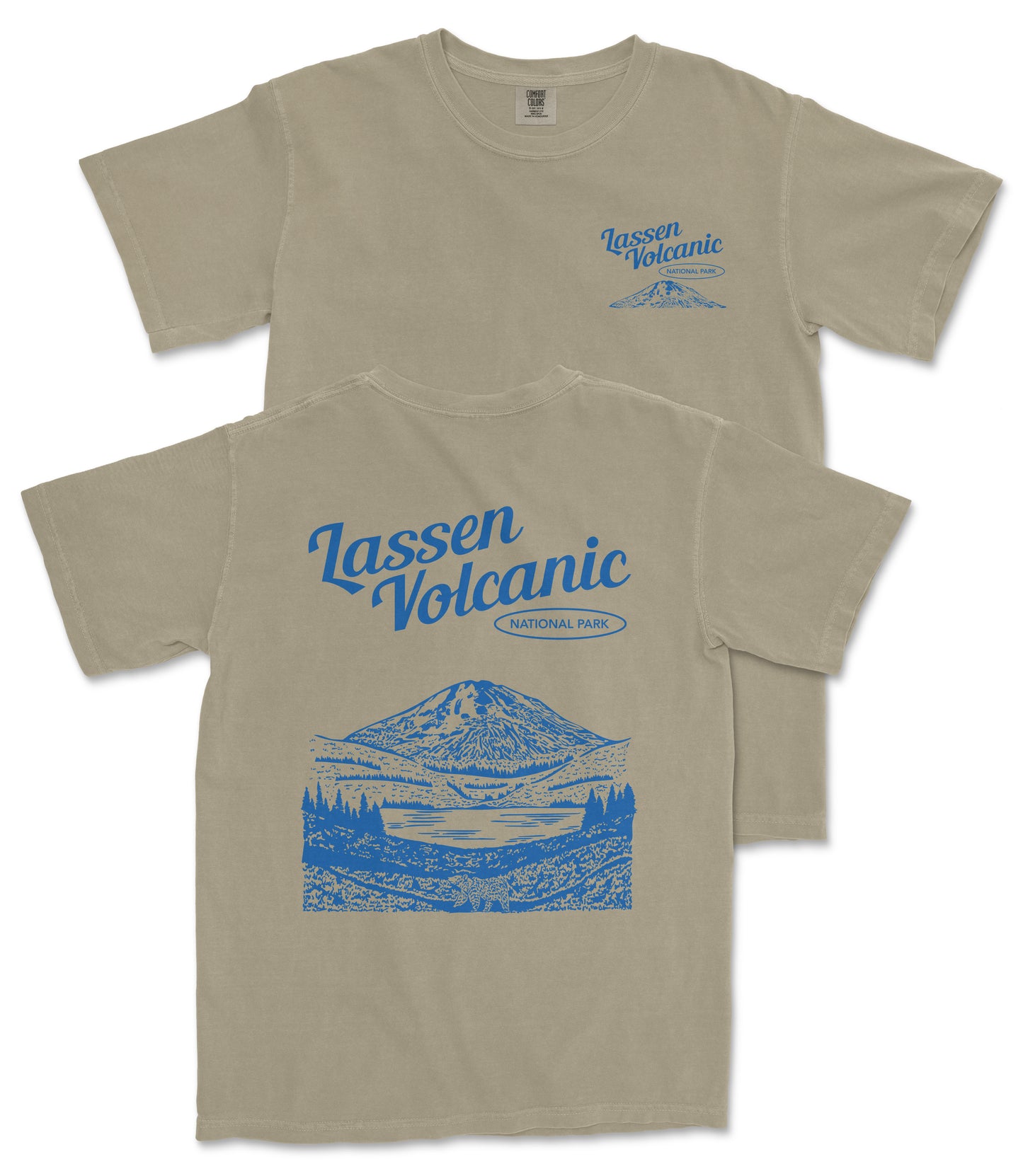 a beige t-shirt with a graphic design depicting a mountain landscape, including a lake and trees. The design also includes the text "Lassen Volcanic National Park" printed on the back of the shirt.