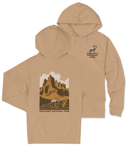 A tan hooded sweatshirt with a graphic design depicting a mountain landscape and the text "Badlands National Park" printed on the back.