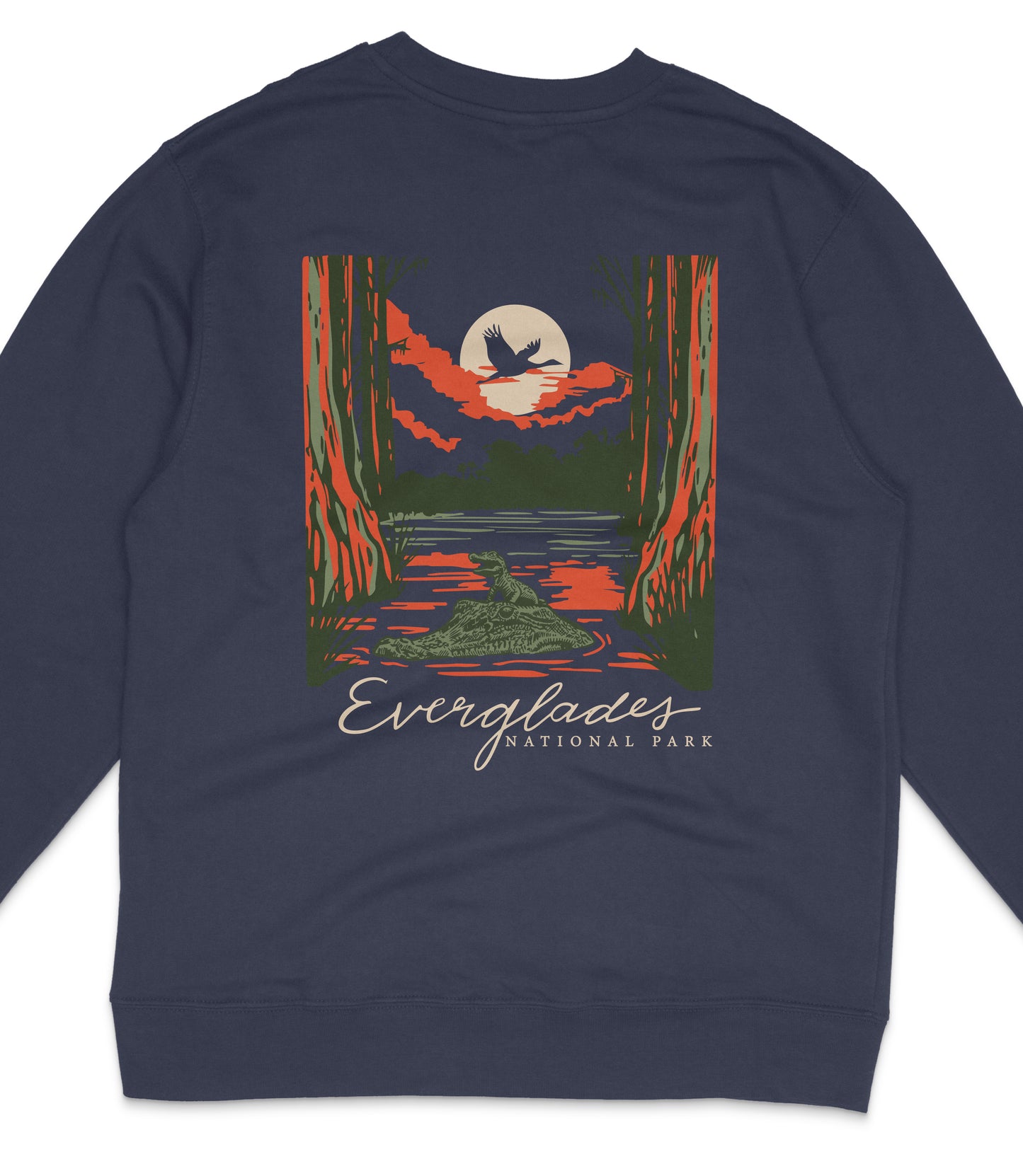 a sweatshirt with a graphic design depicting a sunset over a forest, with a bird flying in the sky.