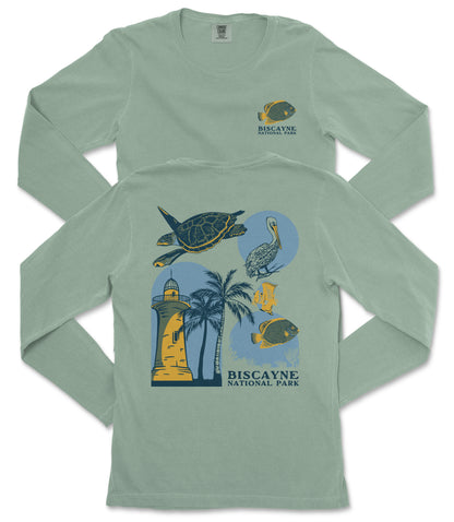 A green long-sleeved t-shirt with a graphic design depicting various marine life and landmarks, including a lighthouse, a turtle, a crane, and palm trees.