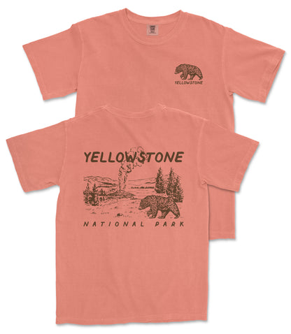A pink t-shirt with a graphic design depicting a bear and a landscape, along with the text "Yellowstone National Park" printed on it.