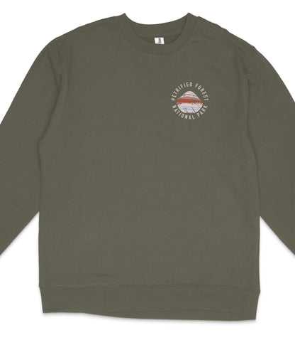 A dark green long-sleeved shirt with a round logo on the left side.