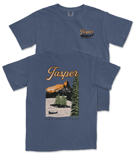 A blue t-shirt with a graphic design depicting a mountain landscape, a canoe, and the text "Jasper National Park" printed on it.