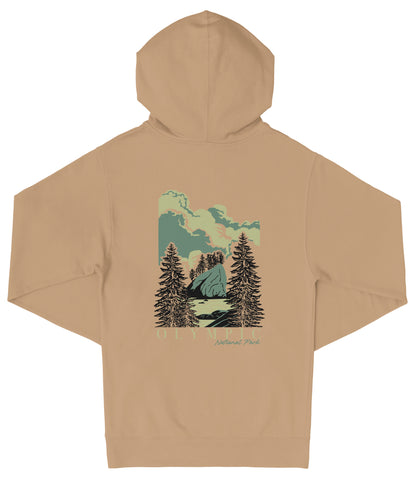 A beige hooded sweatshirt with a graphic design depicting a scenic landscape with pine trees, mountains, and a cloudy sky.