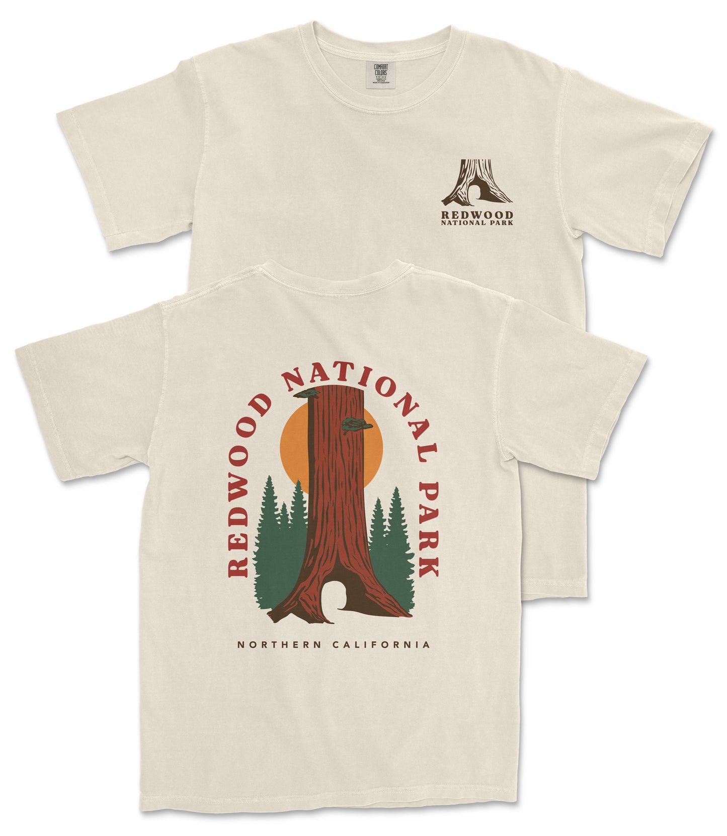 a cream-colored t-shirt with a graphic design depicting a tall tree with a sunburst on its trunk, surrounded by pine trees. The text on the t-shirt reads "REDWOOD NATIONAL PARK NORTHERN CALIFORNIA".
