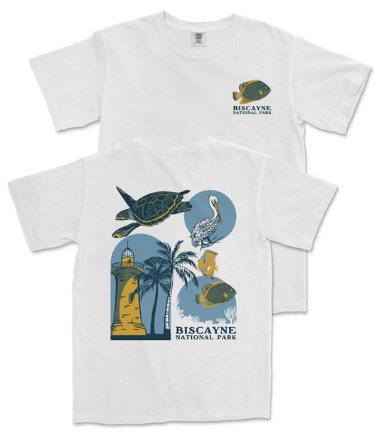 A white t-shirt with a graphic design featuring various sea creatures and landmarks, including a lighthouse, palm trees, and a tropical bird.